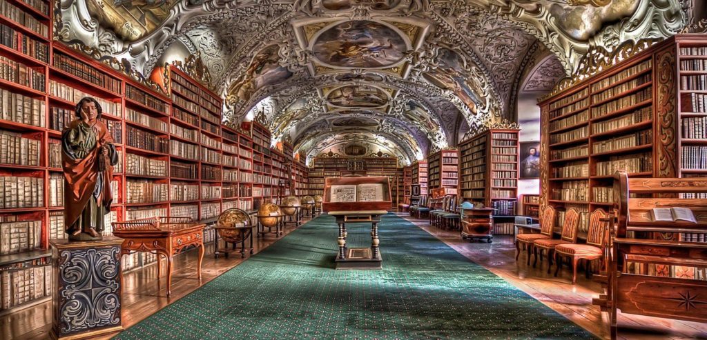 Bibliothek mit vielen Büchern, in der Mitte ist ein Buch aufgeschlagen auf einem Altar